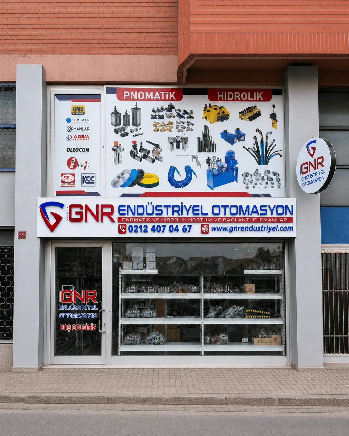 GNR Endüstriyel’in İkitelli OSB’deki mağazası: vitrinde pnömatik ve hidrolik ürün panosu, üzerinde GNR Endüstriyel Otomasyon tabelası